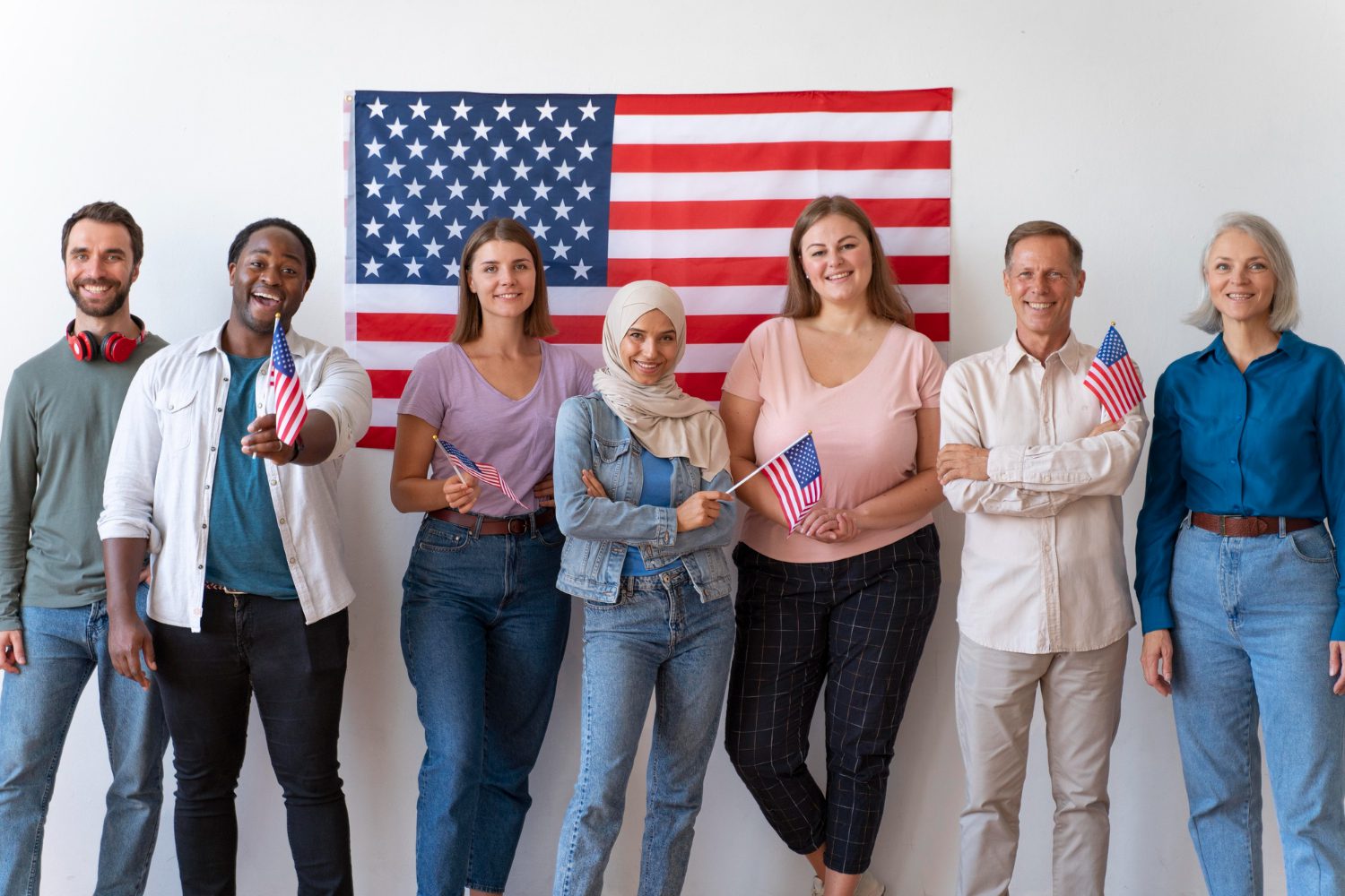 Diverse group holding American flags smiling