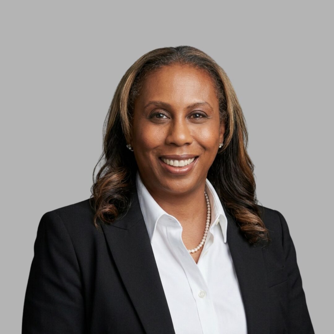 Smiling businesswoman in black blazer, pearl necklace