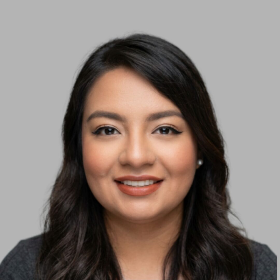 Smiling professional headshot of woman on gray background
