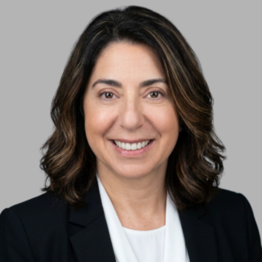 Smiling professional person in blazer, gray background